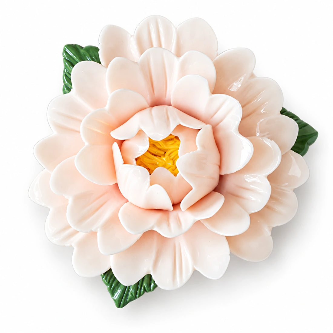 Aimant pivoine en céramique ivoire rosé, avec des feuilles vertes sur fond blanc.