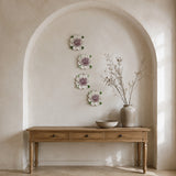 Multiple 15 cm Extra Large Ruffled Peony ceramic wall flowers with plum purple accent arranged as a wall grouping in a warm neutral interior.