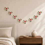 Multiple 7 cm Small Lotus Bloom ceramic wall flowers with rose red accent arranged as a wall grouping in a warm neutral interior.