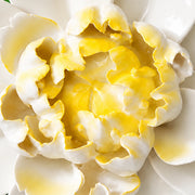 Close frontal view of the golden yellow center and layered glazed petals of the Extra Large Ruffled Peony ceramic wall flower.