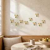 Multiple 7 cm Small Lotus Bloom ceramic wall flowers with golden yellow accent arranged as a wall grouping in a warm neutral interior.