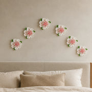 Multiple 12 cm Large Ruffled Peony ceramic wall flowers with rose red accent arranged as a wall grouping in a warm neutral interior.