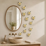 Multiple 7 cm Small Ruffled Peony ceramic wall flowers with golden yellow accent arranged as a wall grouping in a warm neutral interior.