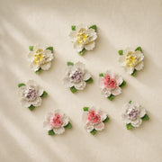 Small Ruffled Peony ceramic wall flowers with golden yellow, plum purple and rose red accents arranged together on a warm neutral wall.