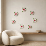 Multiple 9 cm Medium Lotus Bloom ceramic wall flowers with rose red accent arranged as a wall grouping in a warm neutral interior.
