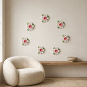 Multiple 9 cm Medium Lotus Bloom ceramic wall flowers with rose red accent arranged as a wall grouping in a warm neutral interior.