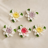 Large Lotus Bloom ceramic wall flowers with golden yellow, plum purple and rose red accents arranged together on a warm neutral wall.