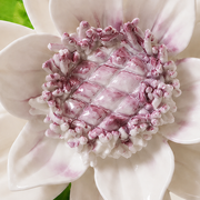 Close frontal view of the plum purple center and layered glazed petals of the Medium Lotus Bloom ceramic wall flower.