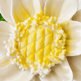 Close frontal view of the golden yellow center and layered glazed petals of the Medium Lotus Bloom ceramic wall flower.