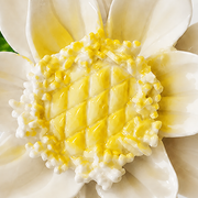 Close frontal view of the golden yellow center and layered glazed petals of the Medium Lotus Bloom ceramic wall flower.
