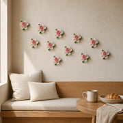 Multiple 7 cm Small Ruffled Peony ceramic wall flowers with rose red accent arranged as a wall grouping in a warm neutral interior.
