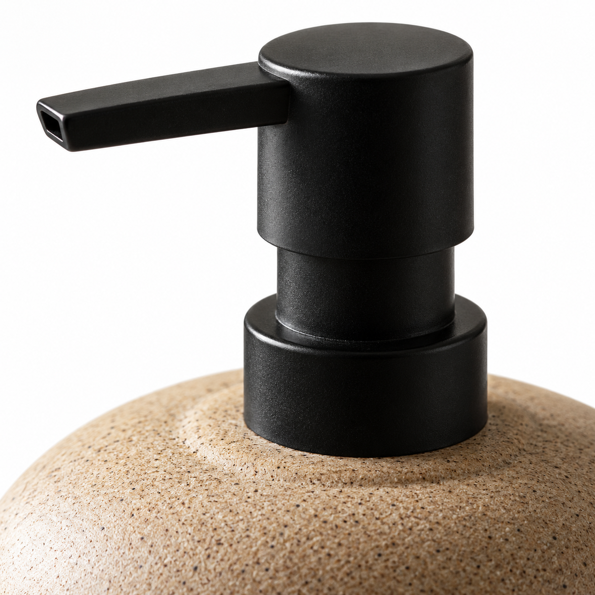 Macro view of the matte black pump, collar and sandy speckled ceramic shoulder of the Zen Pebble soap dispenser.