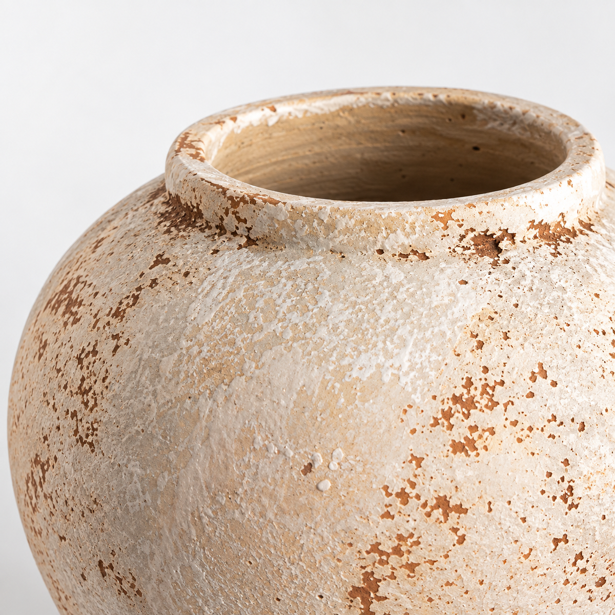 Runde cremeweiße Keramikvase mit verwitterter Glasur: rostbraune Patina und kurzer Rand.