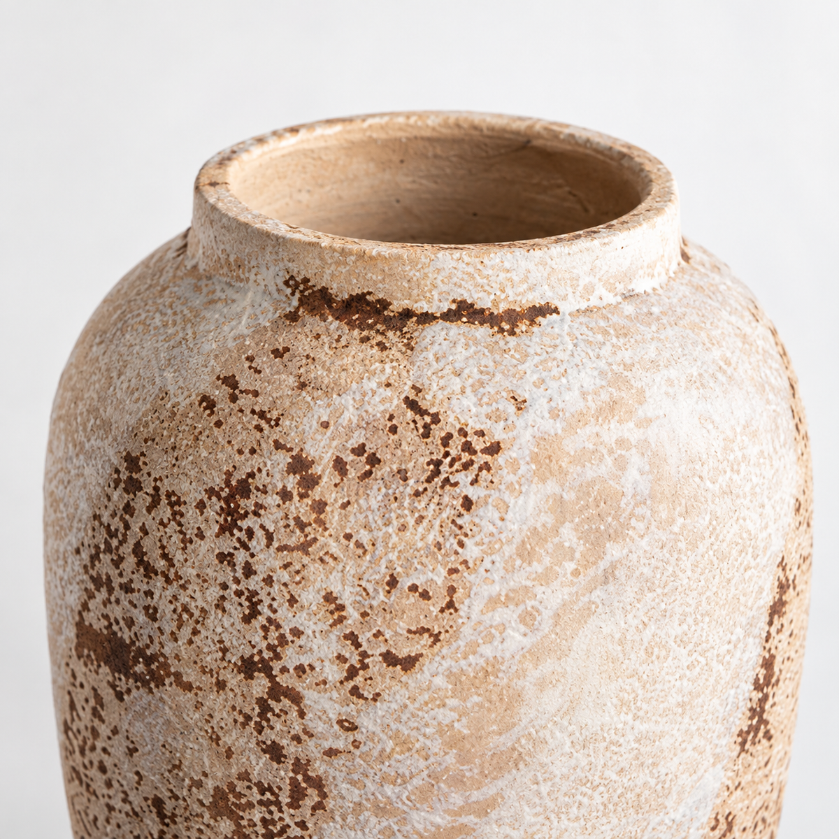 Mittelgroße cremeweiße Keramikvase in Urnenform: rostbraune Patina und gerundete Schulter.