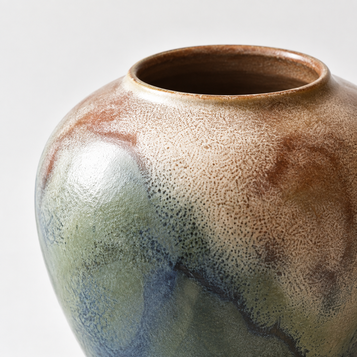 Small round blue-green reactive-glaze ceramic vase: cream, blue and olive reactive glaze.