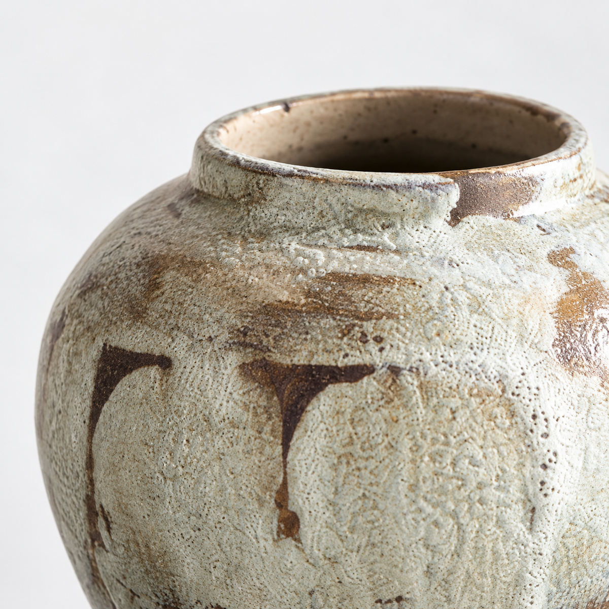 Kleine runde Keramikvase mit gefleckter cremefarbener Glasur: gefleckte cremefarbene Glasur und braune Glasurläufe.