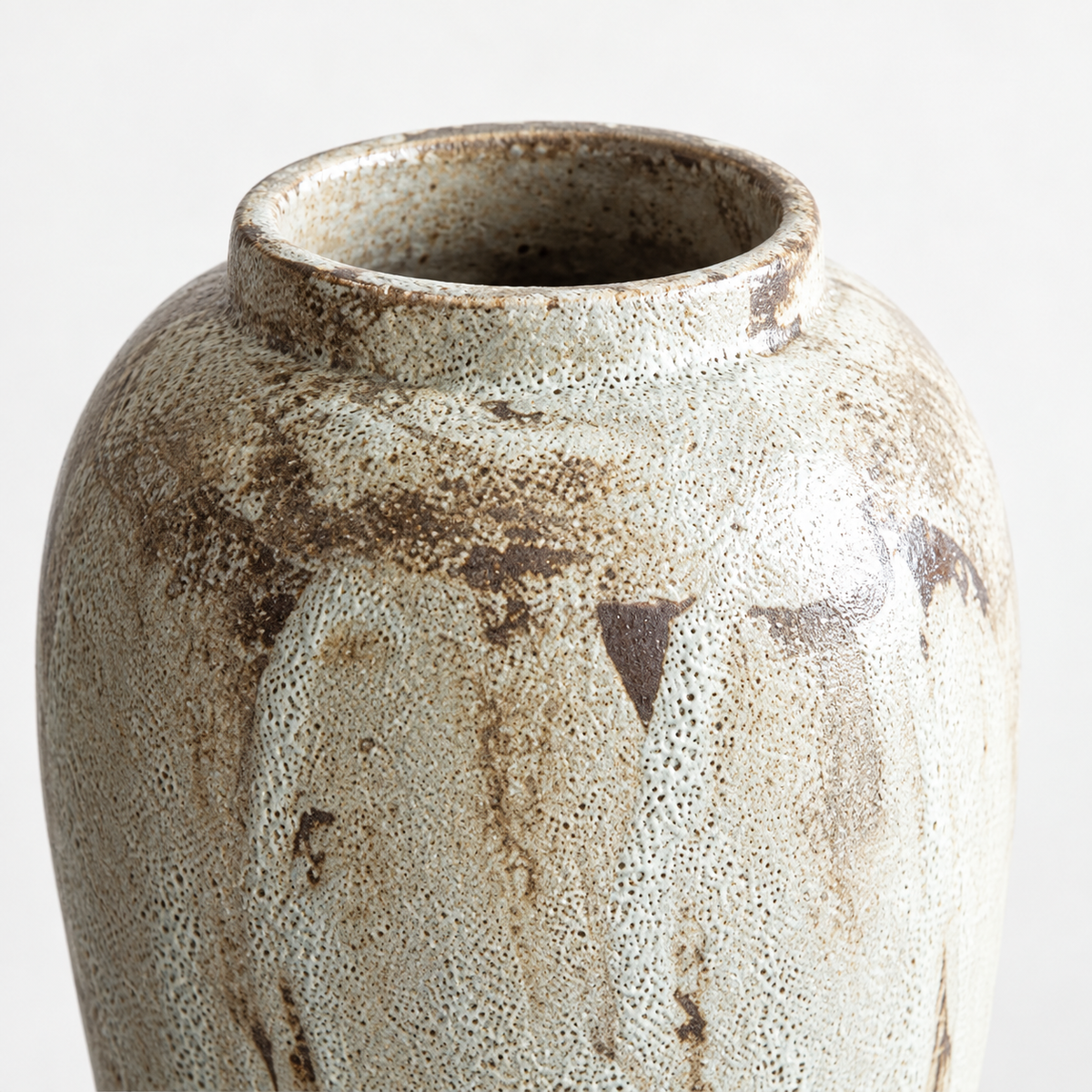 Mittelgroße cremefarbene Keramikvase in Urnenform: braune Glasurstreifen und offene Mündung.