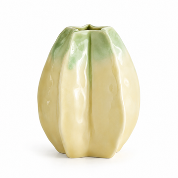 Kleine gelbgrüne Keramikvase in Sternfruchtform vor weißem Studiohintergrund.