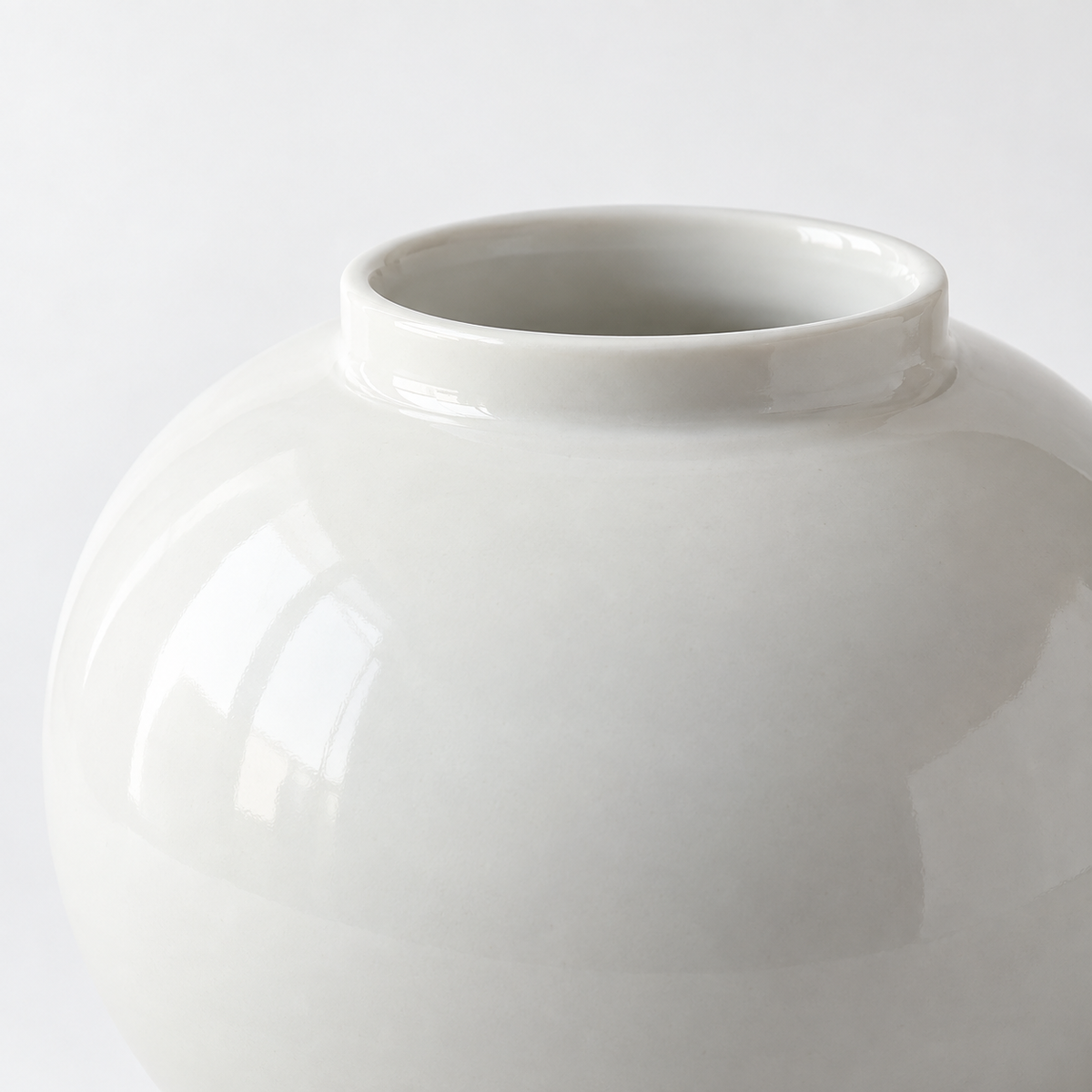 Medium glossy white moon ceramic vase: short rim and smooth rounded white shoulder.