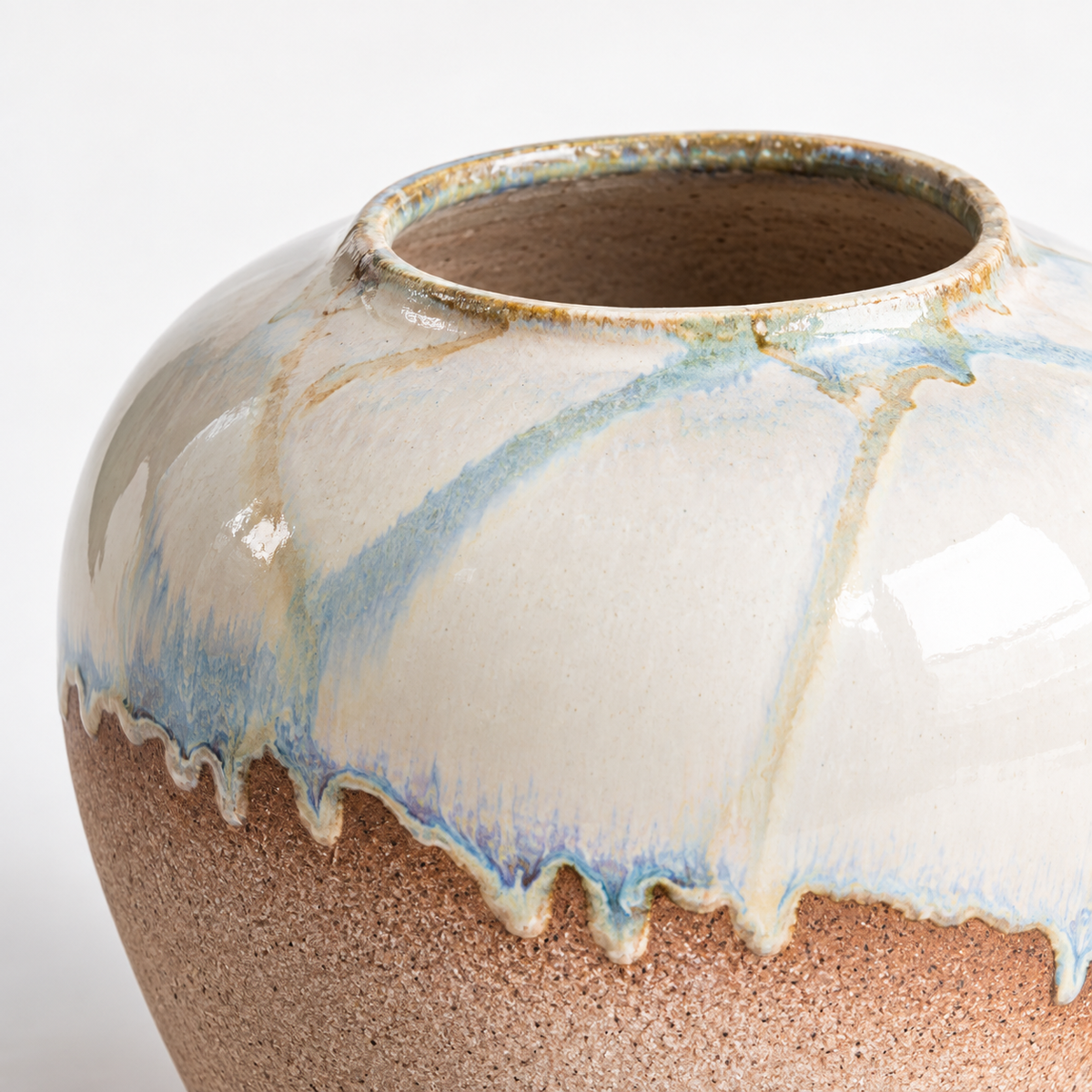 Kleine runde Keramikvase mit zweifarbiger Laufglasur: elfenbeinblaue Glasur über einem sandbraunen Unterteil.