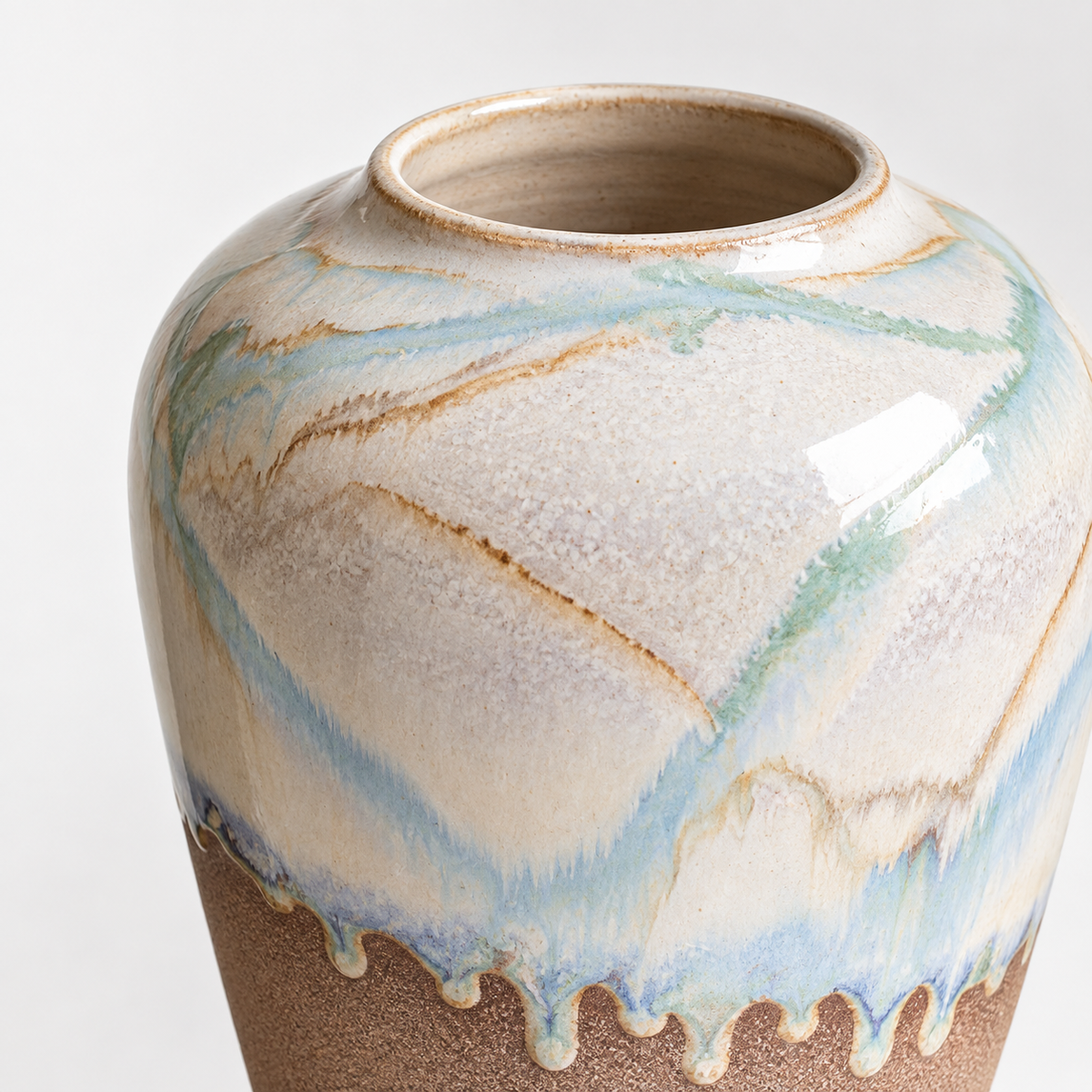 Mittelgroße Keramikvase in Urnenform mit zweifarbiger Laufglasur: fließende elfenbeinblaue Glasur und sandige untere Oberfläche.