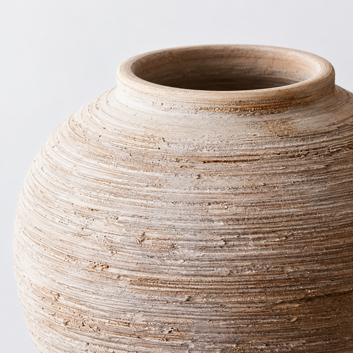 Kleine runde Keramikvase in warmem Elfenbein mit Rippenstruktur: feine waagerechte Rippen und gefleckte elfenbeinfarbene Oberfläche.