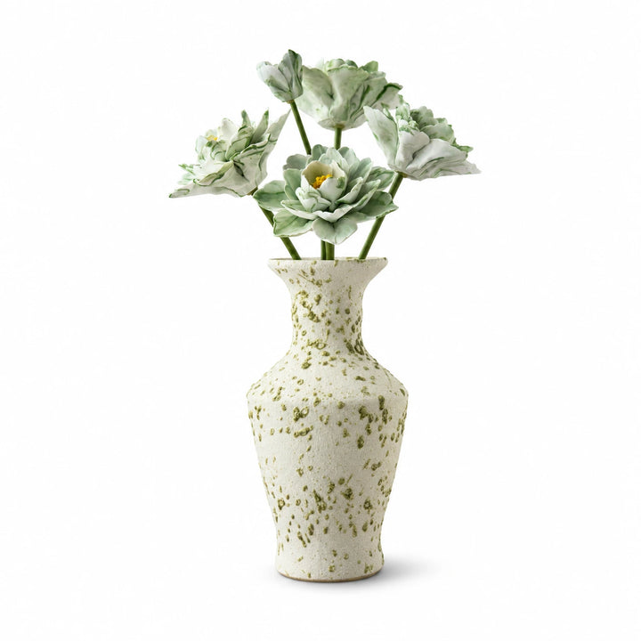 Five green-and-white ceramic flowers in a speckled cream vase on a white background.