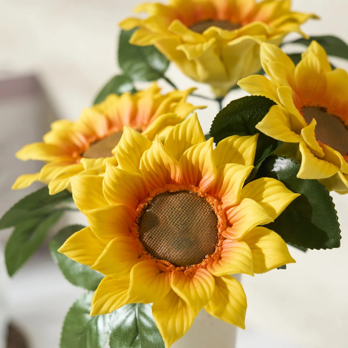 Nahaufnahme gelber Sonnenblumenblütenblätter mit orangefarbenen Ansätzen und brauner Mitte mit Kreuzstruktur.