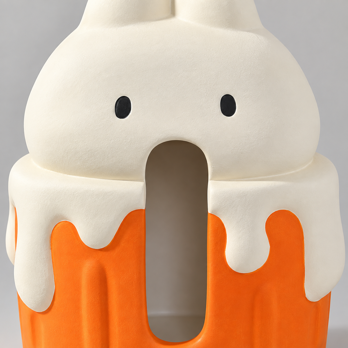 Gros plan du visage du lapin, de la longue ouverture avant, du glaçage crème et de la base cupcake orange