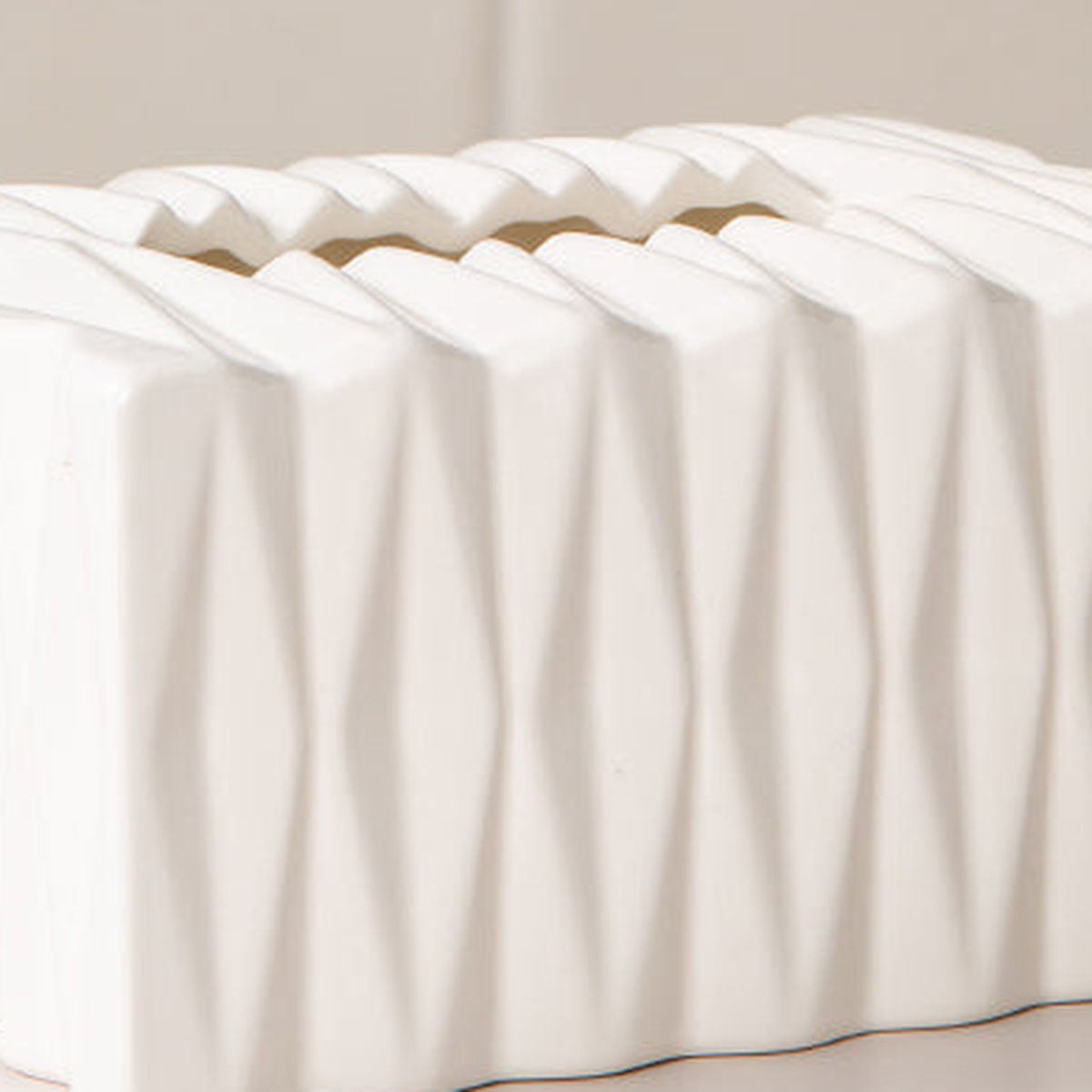 Original close view of white ceramic glaze, raised diamond facets and zigzag tissue opening.