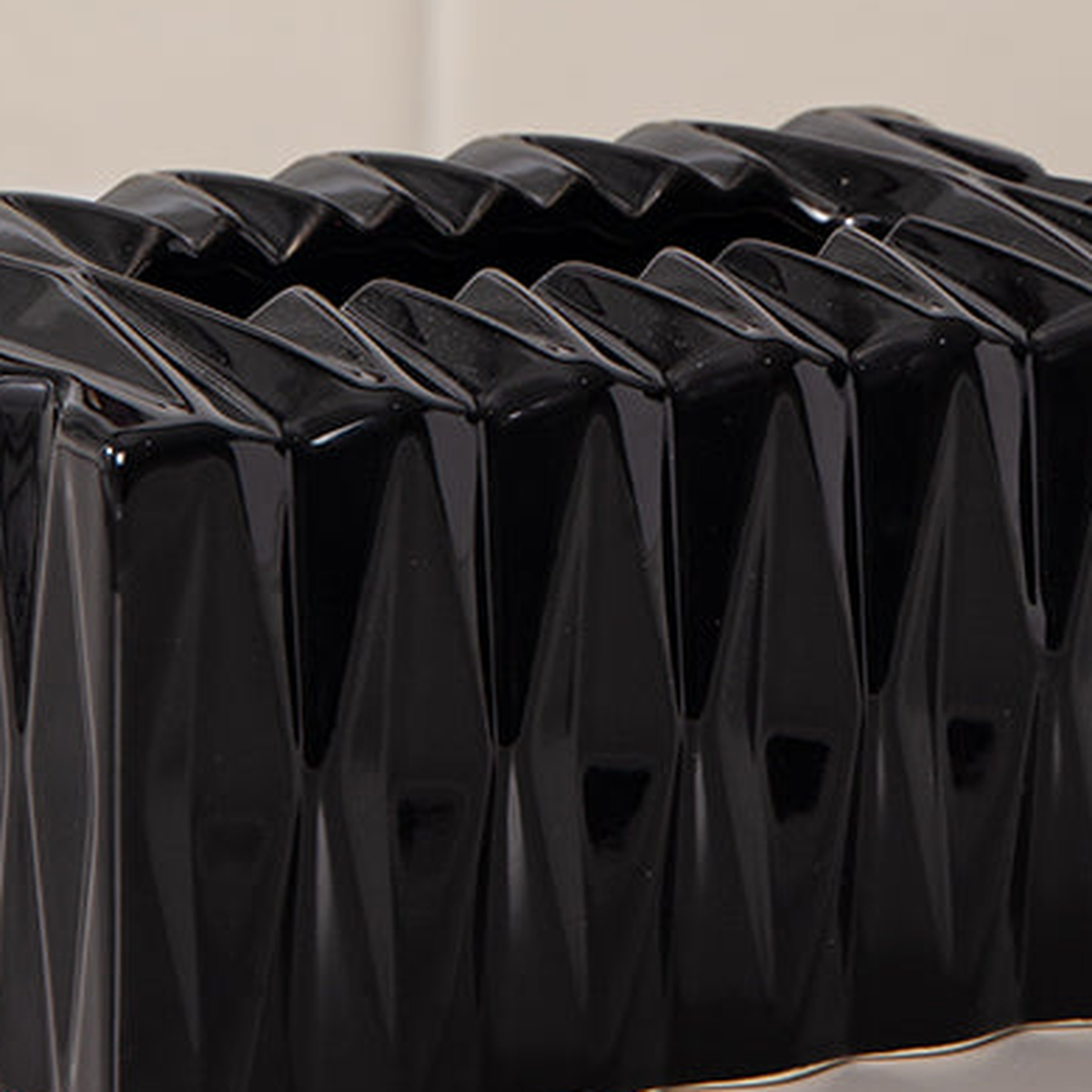 Original close view of black ceramic glaze, raised diamond facets and zigzag tissue opening.