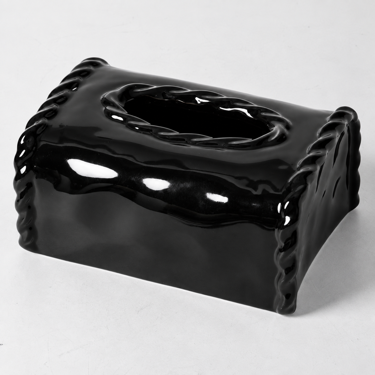 Close view of the glossy black ceramic cover showing sculpted side borders and raised oval opening rim.