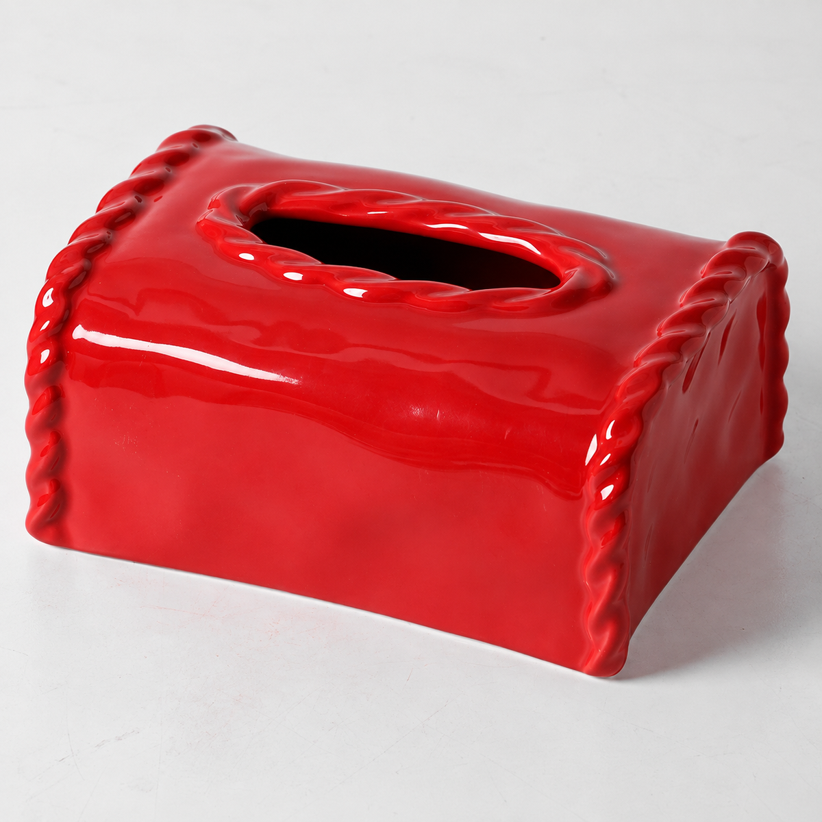 Close view of the red glazed ceramic cover showing the raised oval rim and sculpted side borders.
