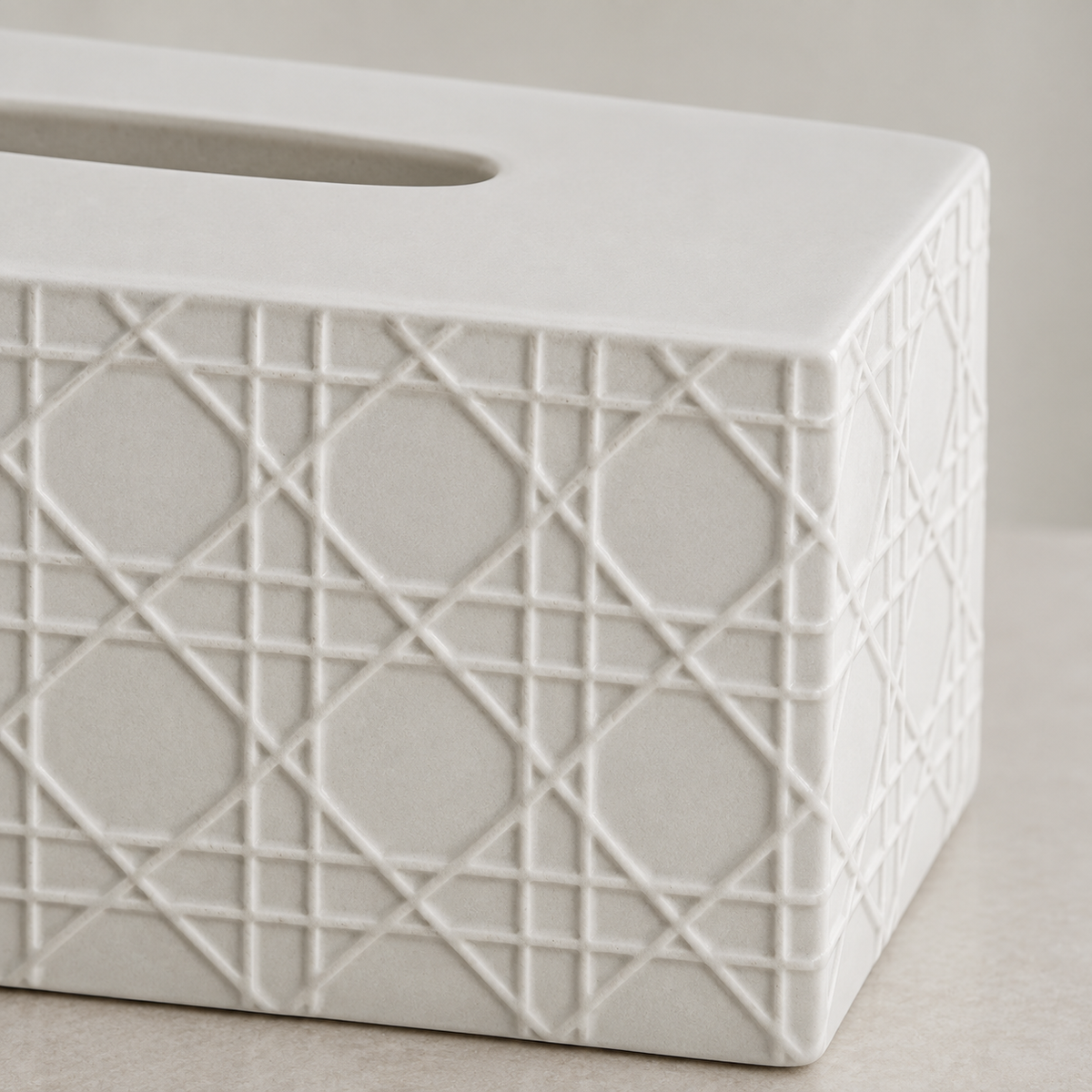 Close view of raised geometric cannage relief, the smooth top and rounded opening in matte white ceramic.