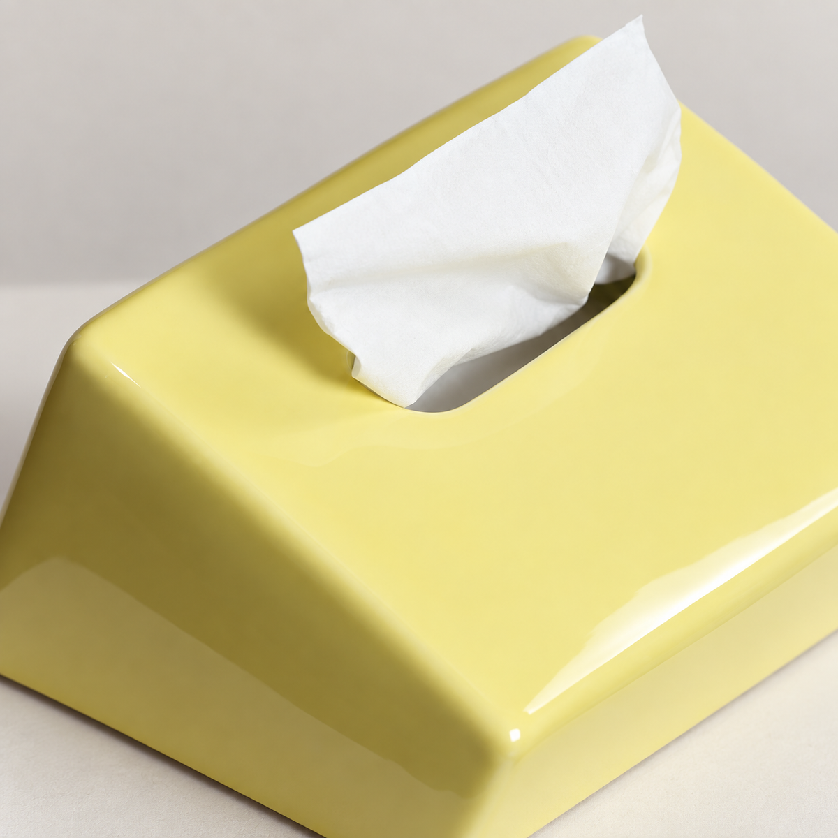 Close view of the yellow tissue cover’s sloping ceramic surface and rounded opening
