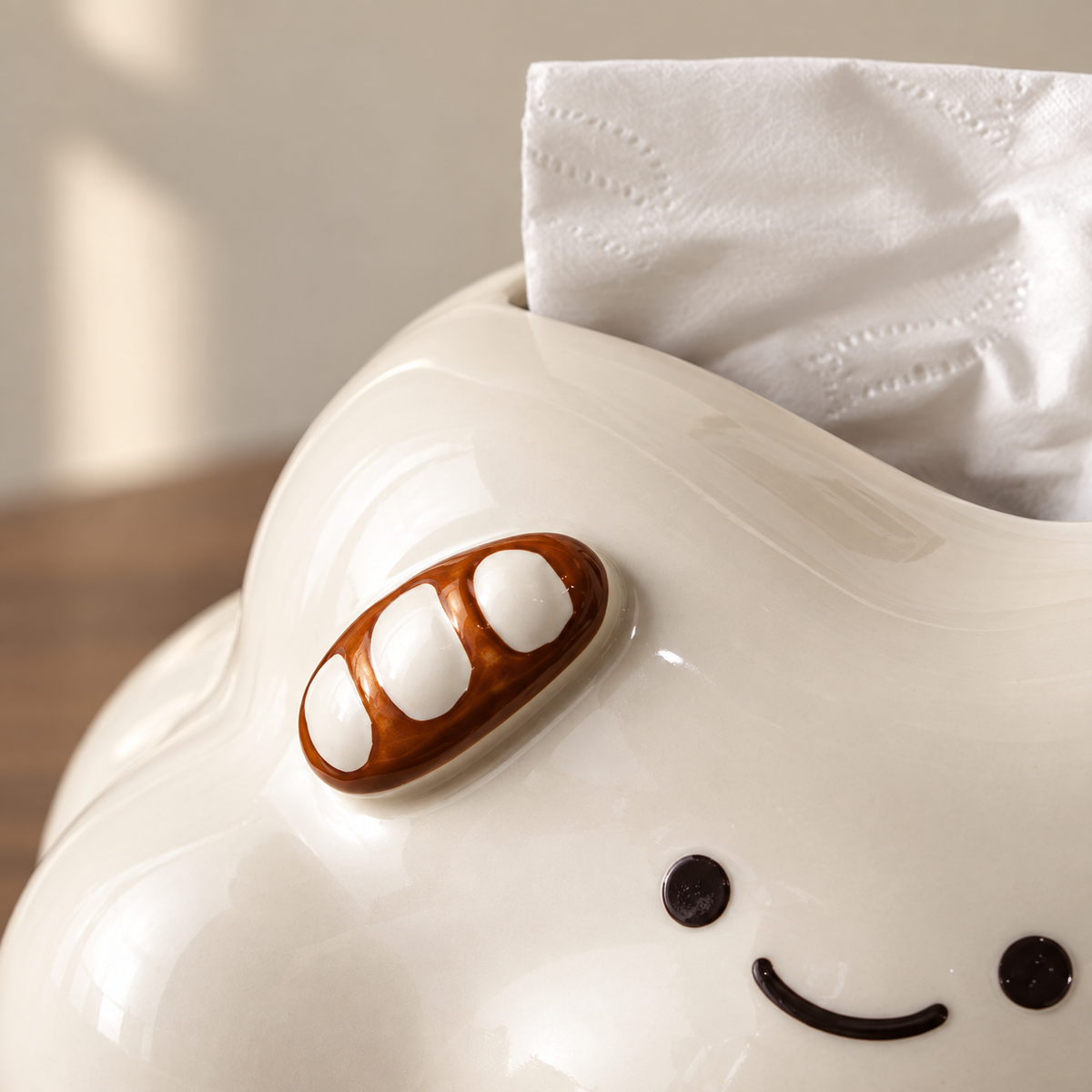 Close view of the brown baguette ornament with three white patches on the glossy cream cloud.