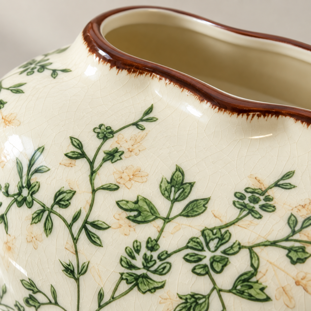 Close view of green floral vines, fine crackle glaze and the brown opening rim on the cream ceramic cover.