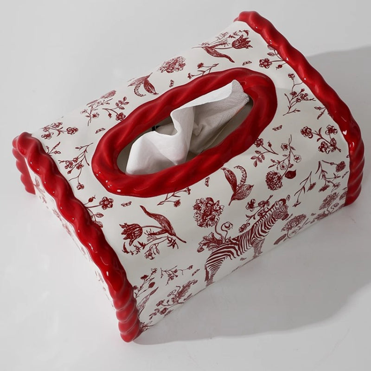 Original crimson ceramic cover photo showing red twisted oval opening, tissue and botanical print.