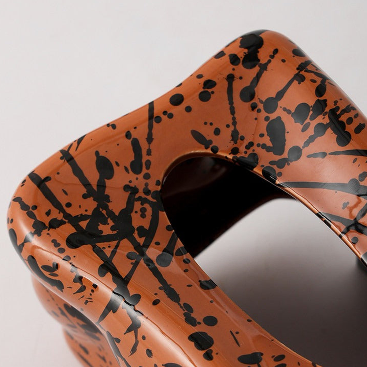 Close view of the original terracotta ceramic glaze, black paint splatters and tissue opening.