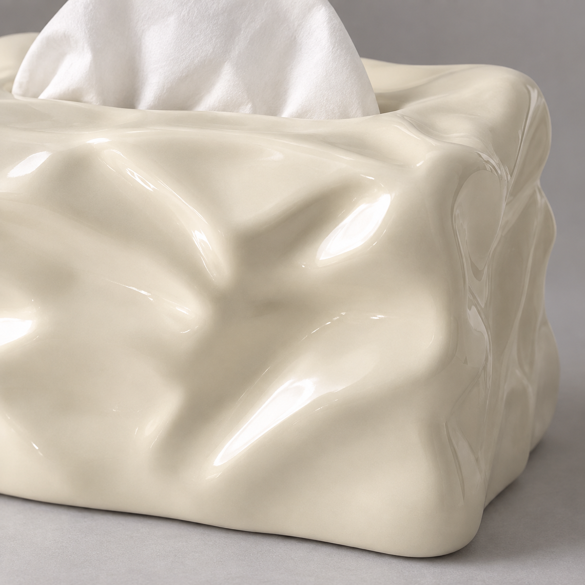 Close view of the white tissue cover’s sculpted folds and glossy ceramic corner