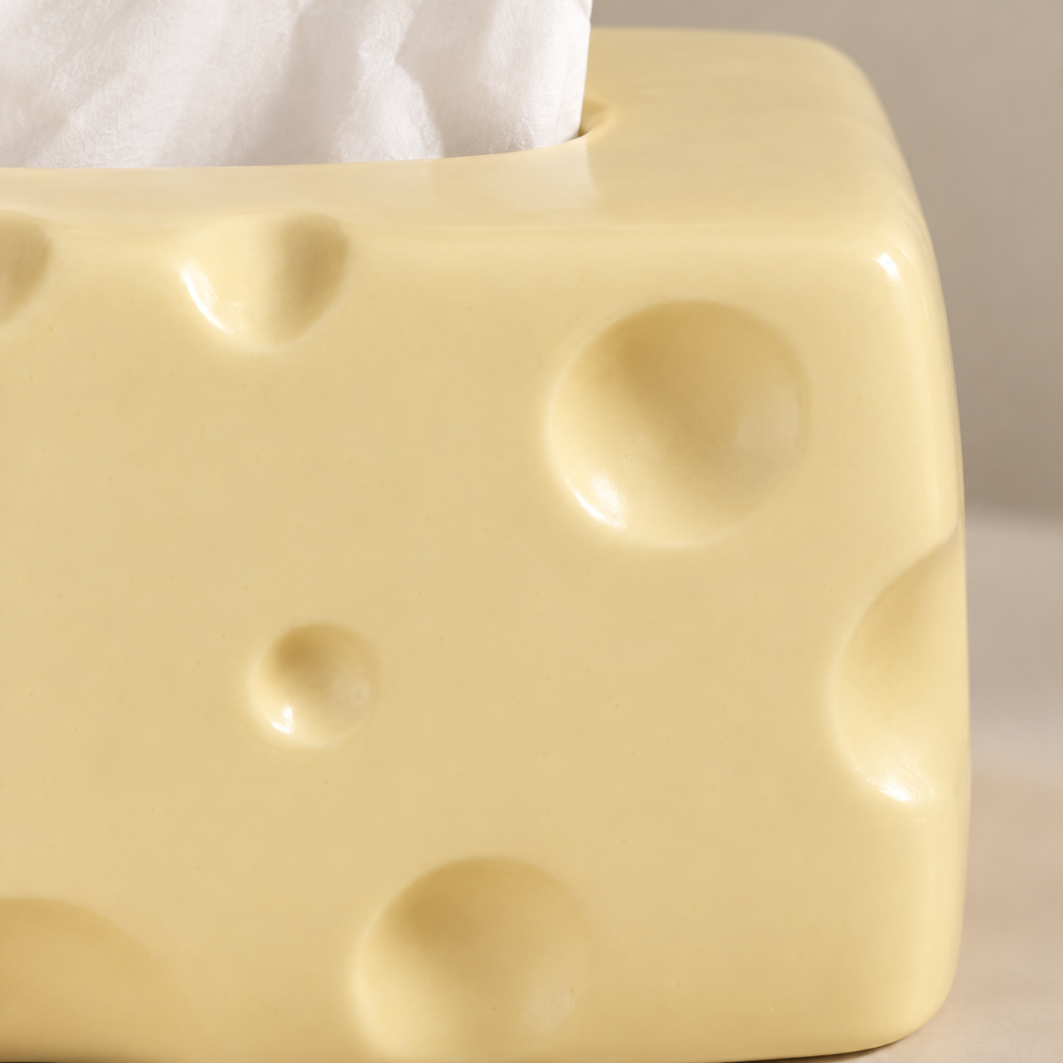 Close view of shallow rounded dimples and soft glazed highlights on the pale-yellow ceramic cover.