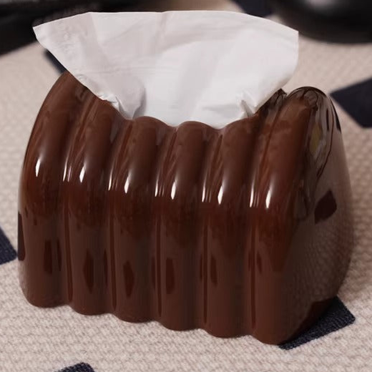 Close view of the amber-brown ceramic cover’s curved ribs, glossy surface and top tissue outlet.