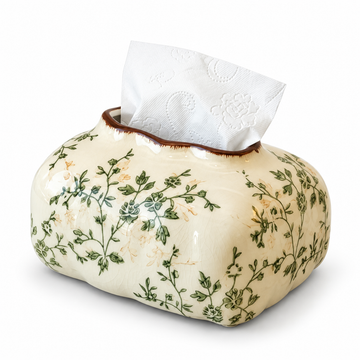Cream ceramic tissue box cover with green floral vines, a brown-edged top opening and a white tissue.