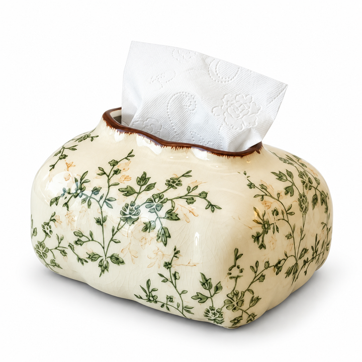Cream ceramic tissue box cover with green floral vines, a brown-edged top opening and a white tissue.