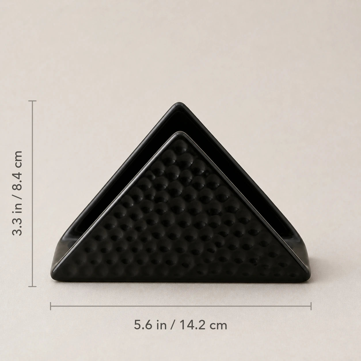Front view of black ceramic napkin holder marked 5.6 inches wide and 3.3 inches high