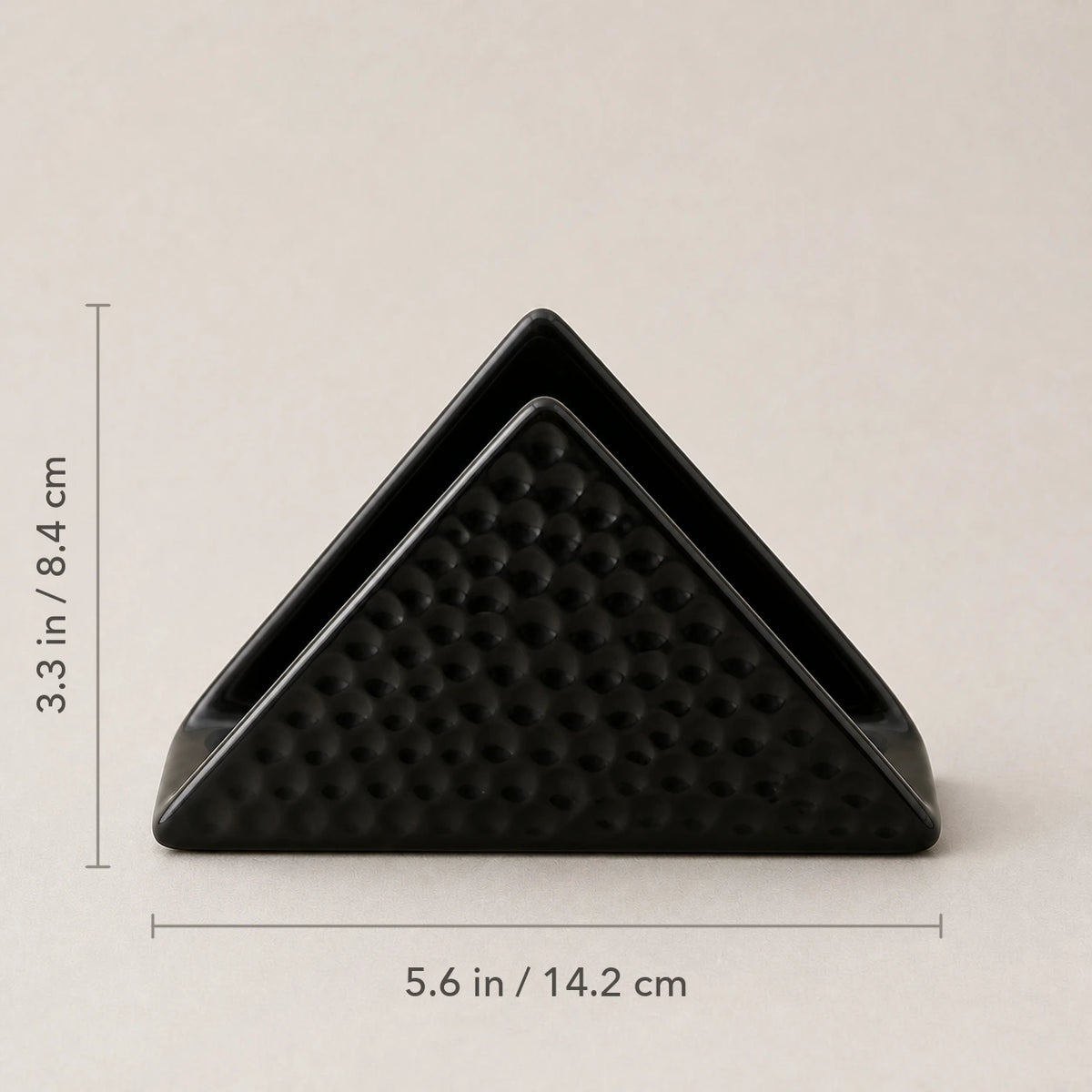 Front view of black ceramic napkin holder marked 5.6 inches wide and 3.3 inches high