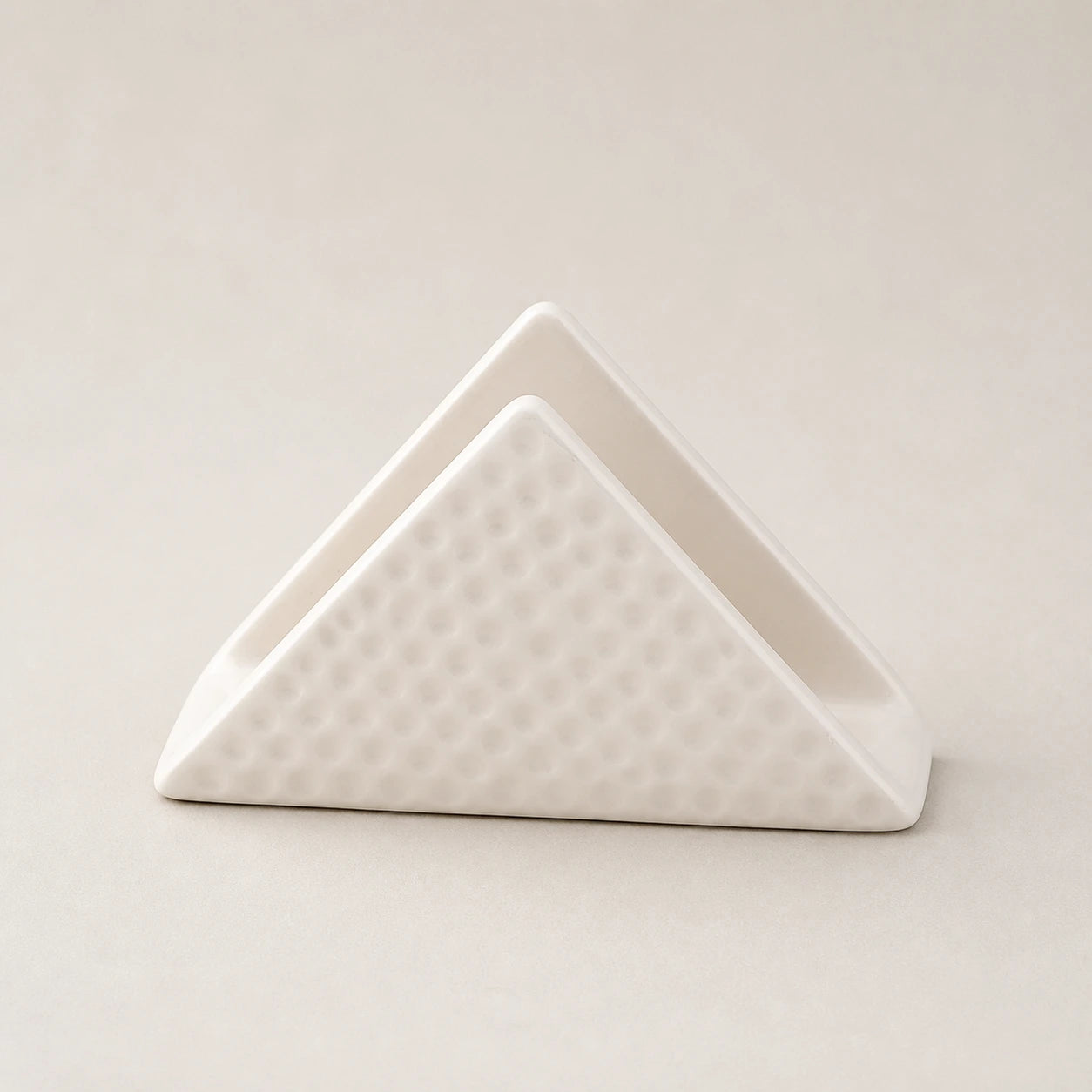 White triangular ceramic napkin holder with dimpled outer panels