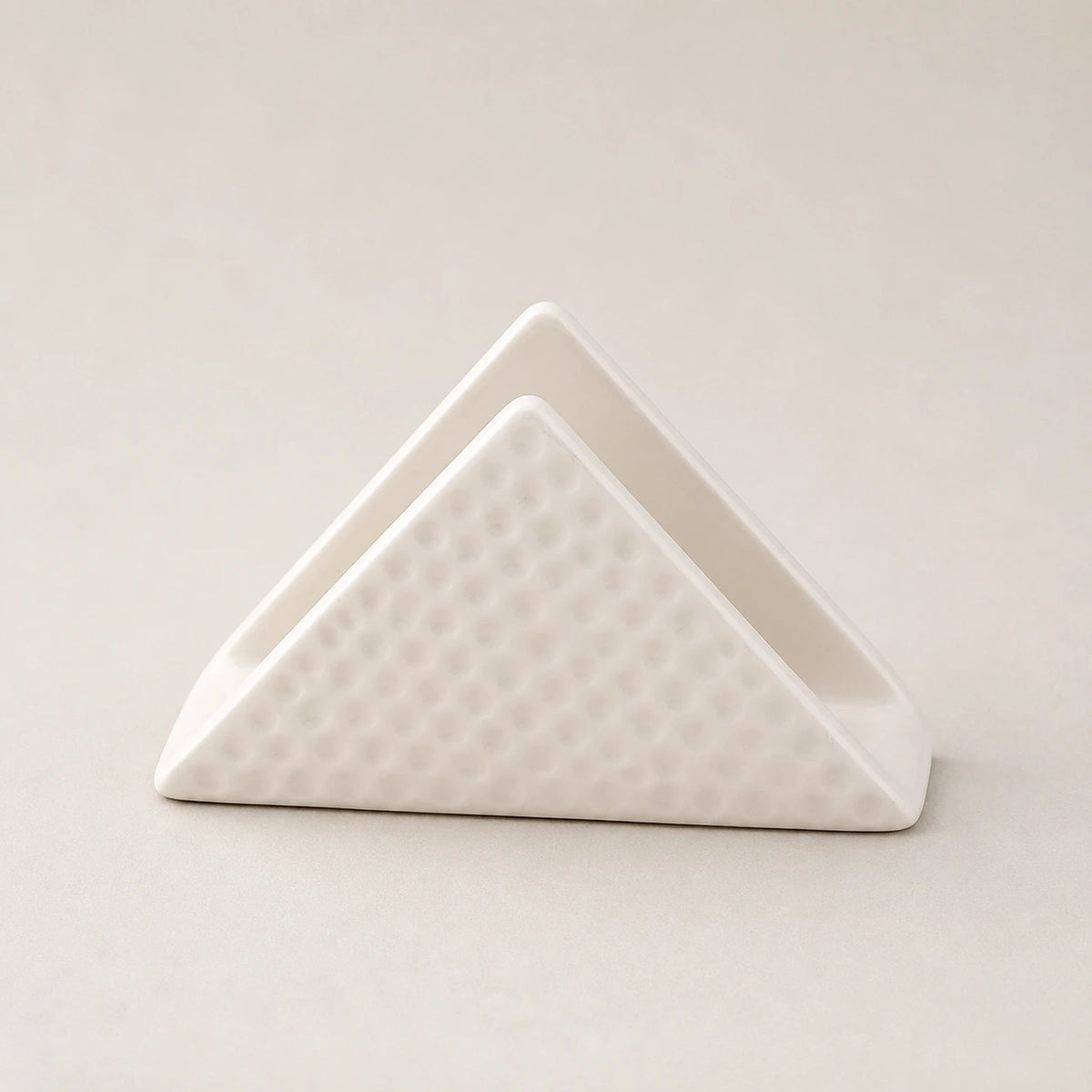 White triangular ceramic napkin holder with dimpled outer panels