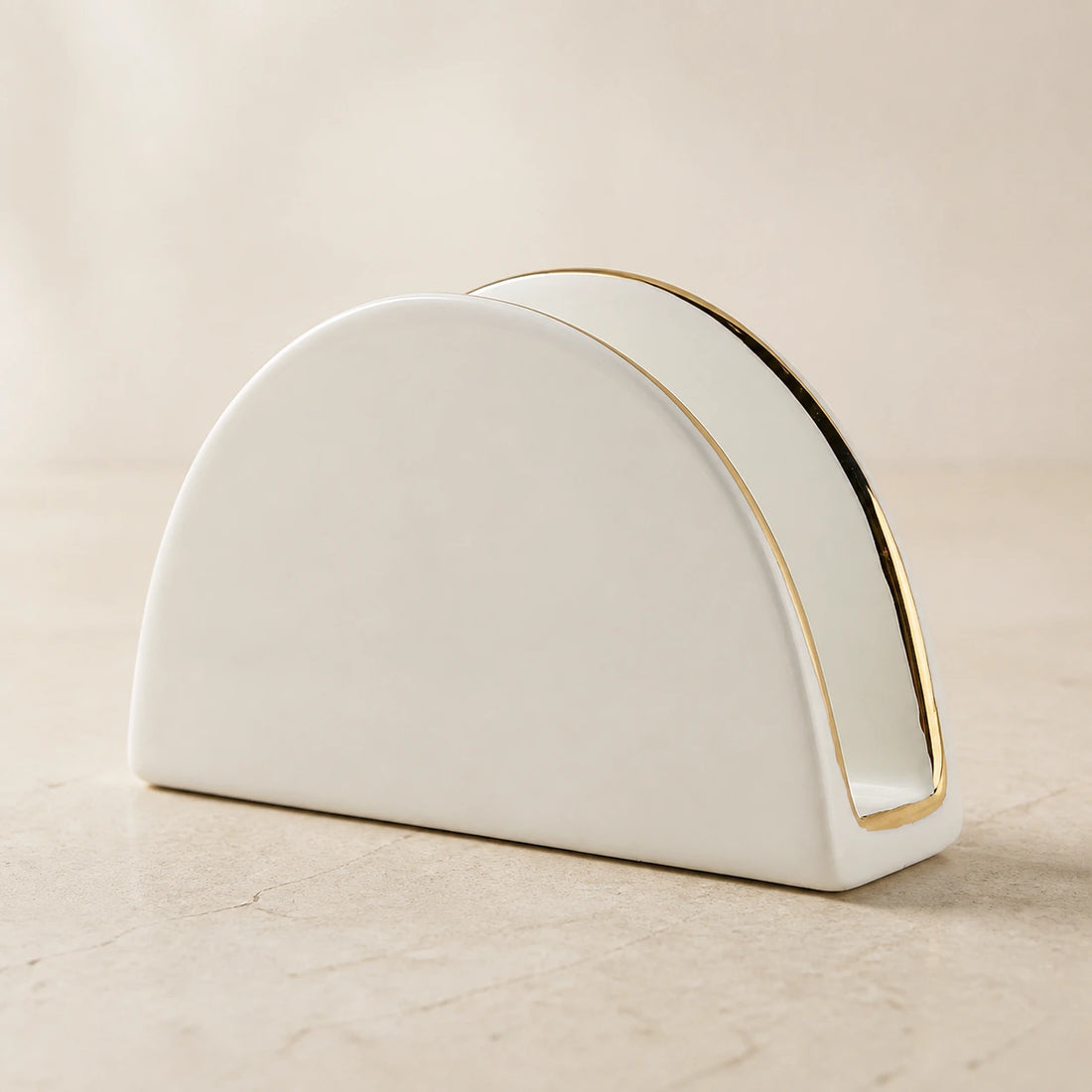 Glossy white arched ceramic napkin holder with a narrow gold-tone rim