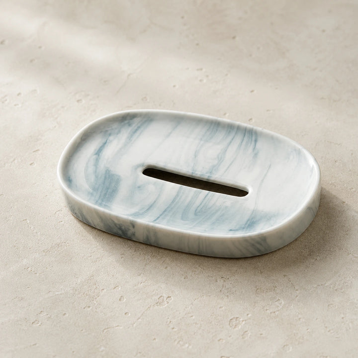 Empty Blue Marble Swirl minimalist oval ceramic soap dish on pale warm stone